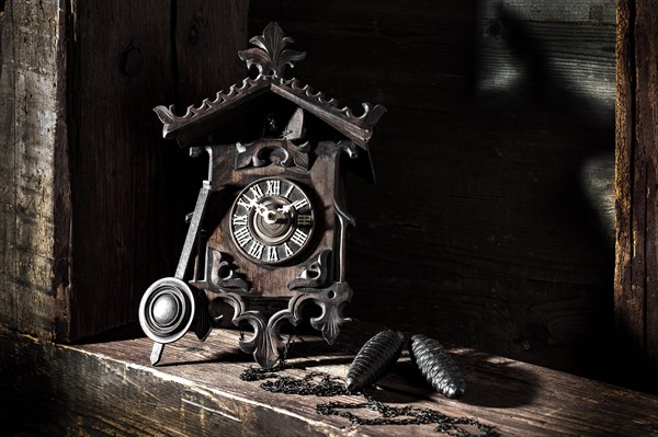 Antique Black Forest cuckoo clock on wooden background