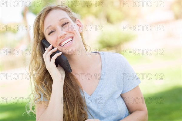 Young adult woman outdoors talking on her smart phone