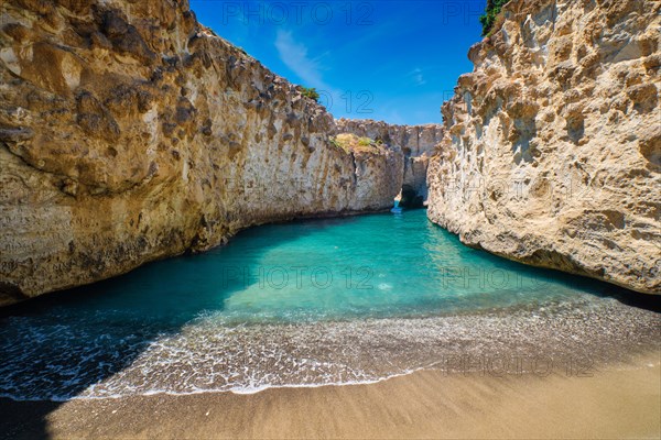 Papafragas hidden beach with crystal clear turquoise water and tunnel rock formations in Milos island