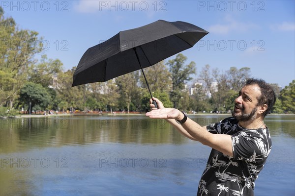 Caucasian man with umbrella on a sunny day