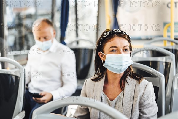 Travelers wearing protective masks commuting by public bus