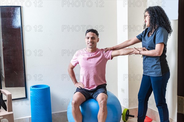 Professional physiotherapist working with female patient in rehabilitation center