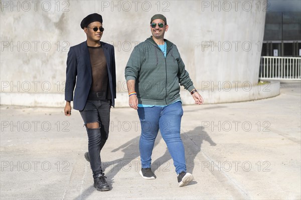 Gay Latino male couple walking in a park