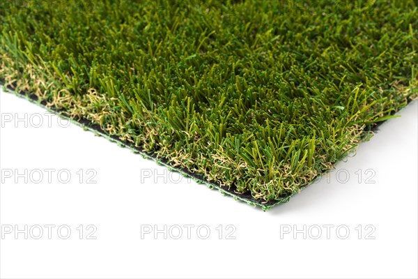 Section of artificial turf grass on white background