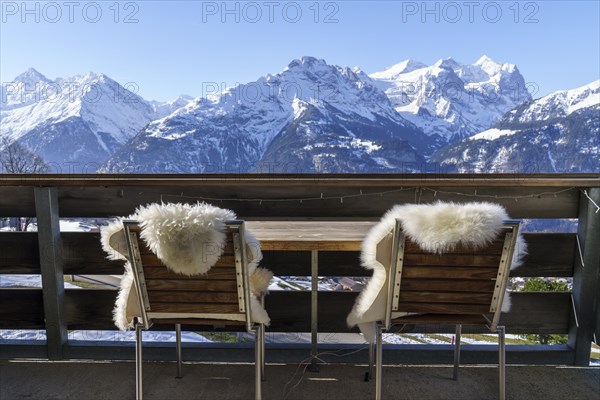 Chairs with fur on balcony in front of mountain panorama