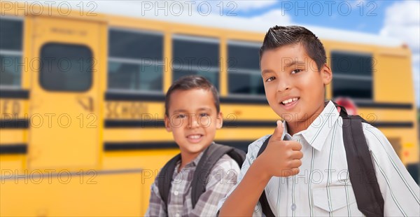 Young hispanic boys walking near school bus