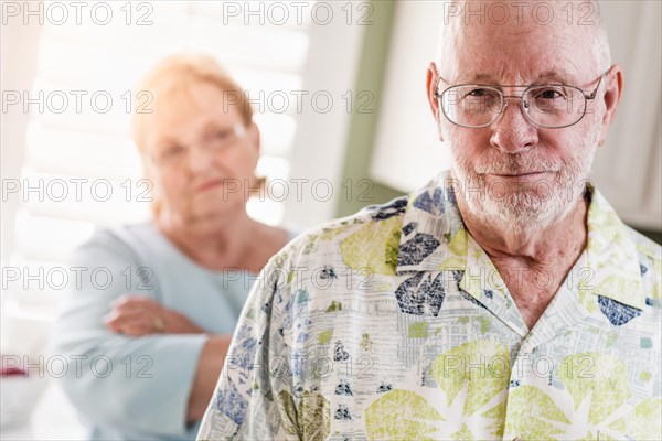 Senior adult couple in dispute or consoling in kitchen of house