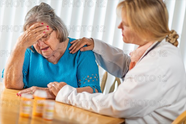 Female doctor consoling distraught senior adult woman