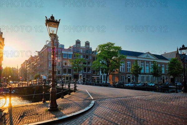 Amsterdam bridge over canal with houses on sunset