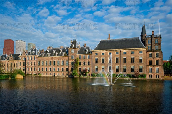 View of the Binnenhof House of Parliament and the Hofvijver lake with downtown skyscrapers in background