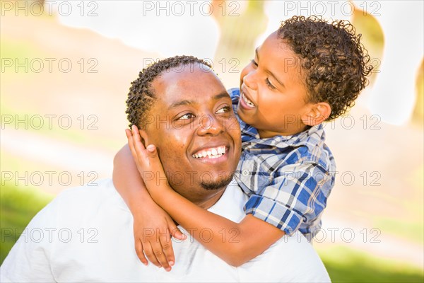 Happy african american father and mixed-race son playing at the park