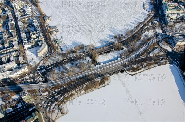 Road and railway bridge over the Alster in winter with ice and snow