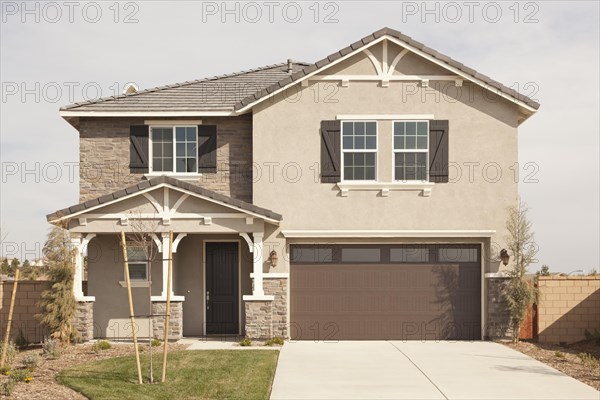 A newly constructed modern home facade and yard