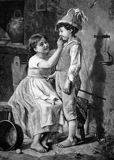 Two children at home. The girl paints the boy's face with war paint