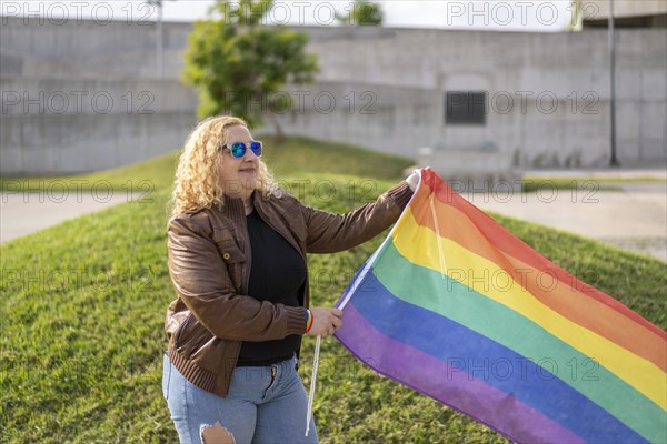 Young blonde woman holding lgbt flag. Concept of freedom and tolerance