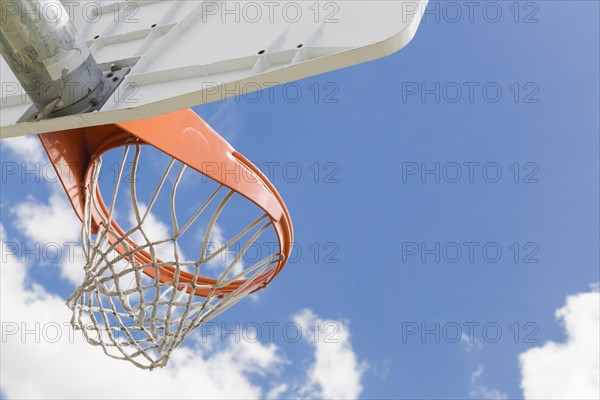 Abstract of community basketball hoop and net against blue sky