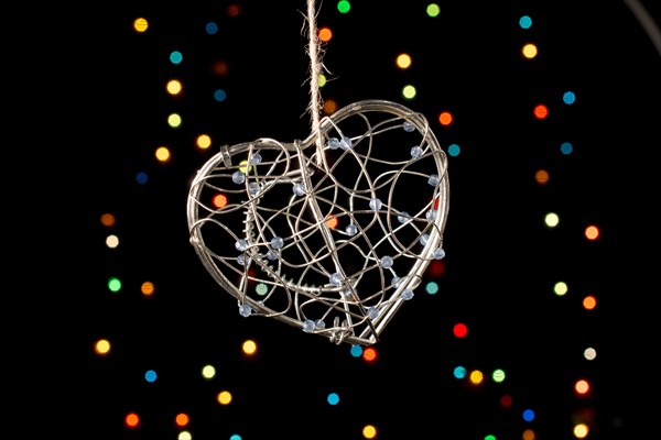 Heart shaped metal cage on a bokeh light background