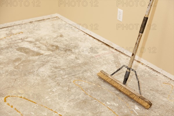Blank concrete house floor with broom ready for flooring installation