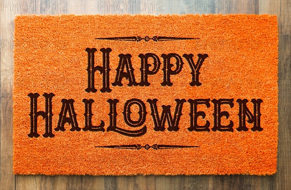 Happy halloween orange welcome mat on wood floor background