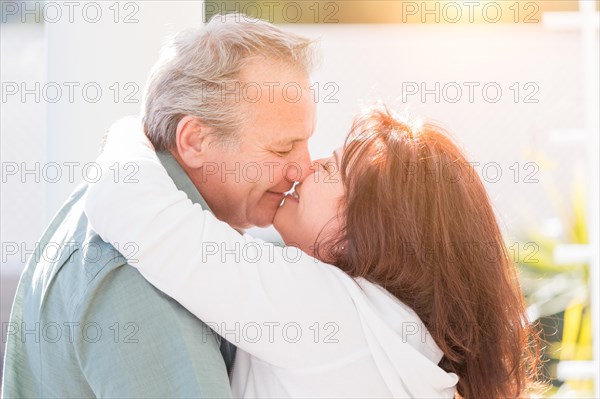 Happy middle aged couple enjoy A romantic slow dance and kiss outside