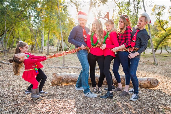 mixed-race family portrait with children tying up group with tinsel rope