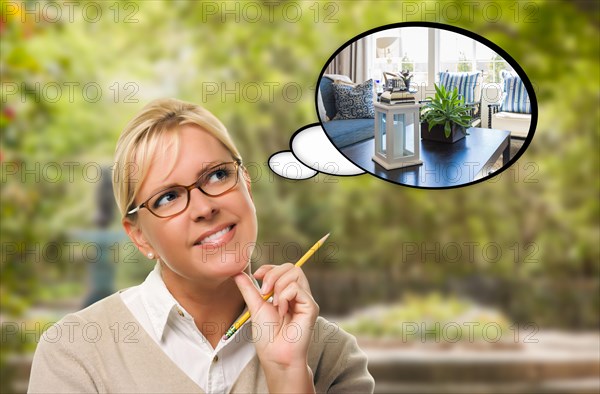 Thoughtful young woman with pencil and new living room in thought bubble