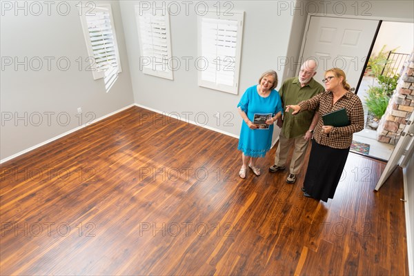 Female real estate agent showing senior adult couple A new home