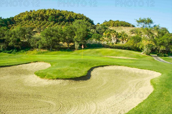 Abstract of golf course sand bunker and green with flag