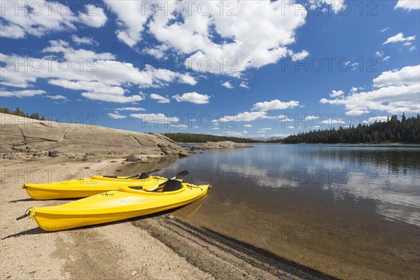 Pair of yellow kayaks on a beautiful mountain lake shore