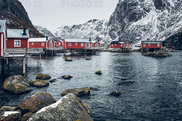 Nusfjord authentic traditional fishing village with traditional red rorbu houses in winter in Norwegian fjord. Lofoten islands