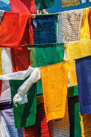 Buddhist prayer flags lungta with Om Mani Padme Hum Buddhist mantra prayer meaning Praise to the Jewel in the Lotus on kora around Tsuglagkhang complex