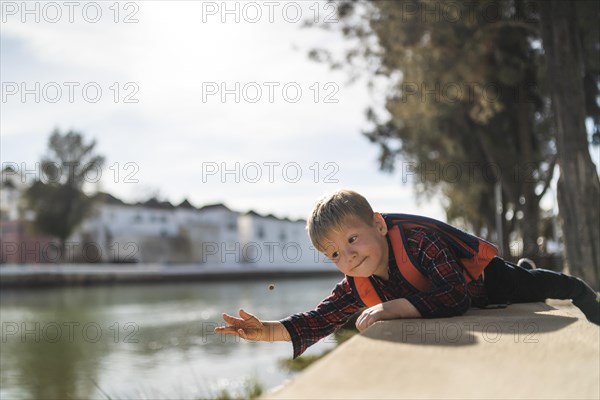 Cute small boy playing with a small ball by the river in Tavira