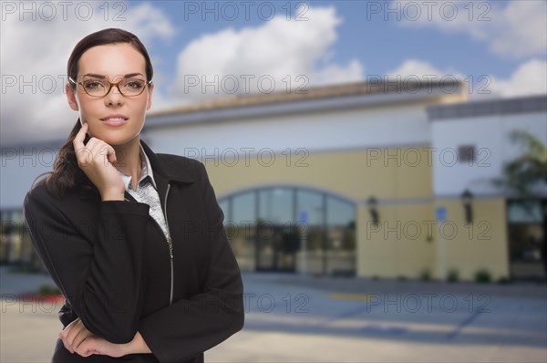 Attractive serious mixed-race woman in front of vacant commercial retail building