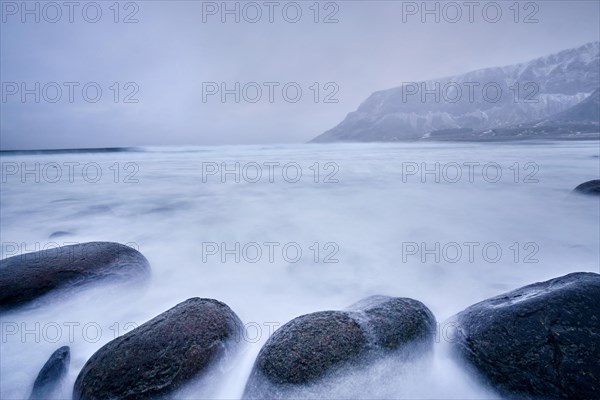 Waves of Norwegian sea surging on stone rocks at Unstad beach