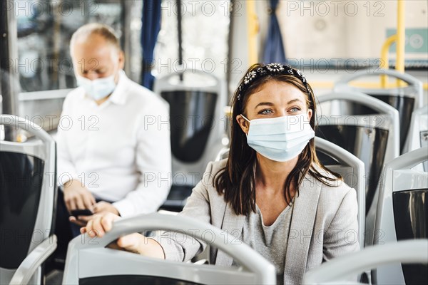 Travelers wearing protective masks commuting by public bus