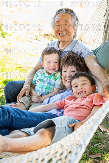 Chinese grandparents in hammock with mixed-race children
