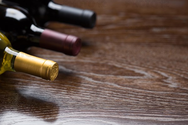 Various wine bottles on a reflective wood surface abstract