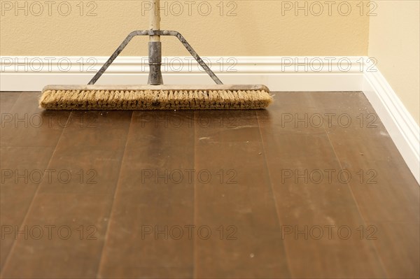 Push broom on a newly installed laminate floor and new baseboards