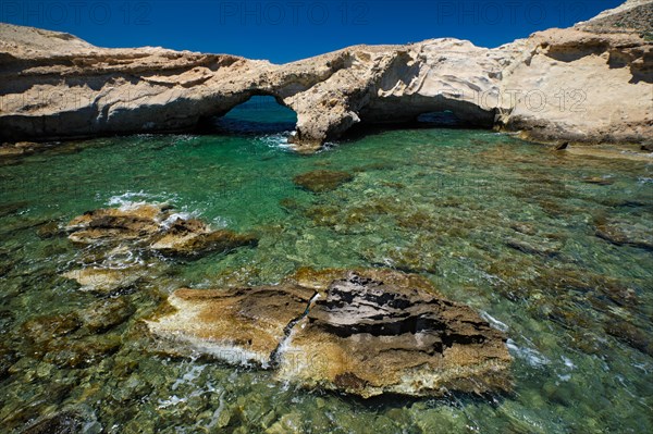 The beach of Agios Konstantinos with crystal clear turquoise water and rock formations in Milos island