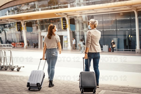 Female friends with luggage approaching the airport ready for the trip