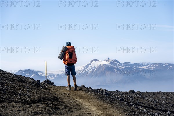 Hikers on trail through volcanic landscape