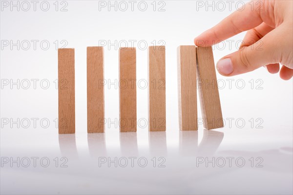 Hand holding wooden domino on a white background