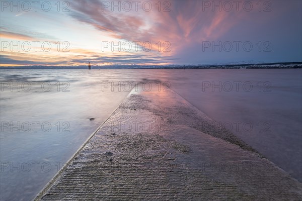 Sunrise on a wintry lake in bad weather