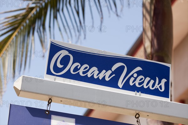 Ocean views real estate sign in front of house