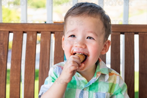 Young mixed-race chinese and caucasian boy enjoying his ice cream cone