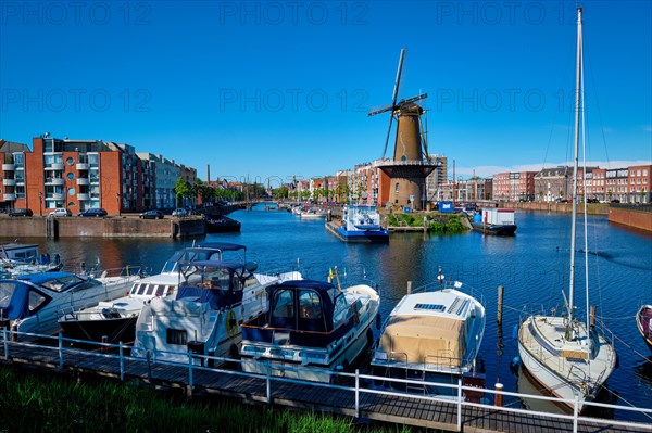 View of the harbour of Delfshaven with the old grain mill known as De Destilleerketel