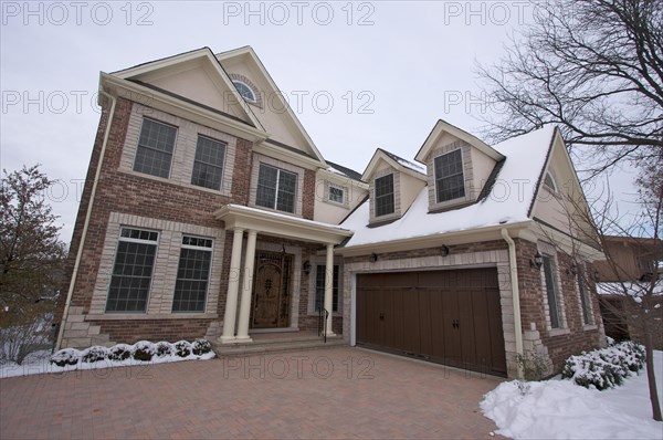 Majestic newly constructed home facade on a blustry winter day