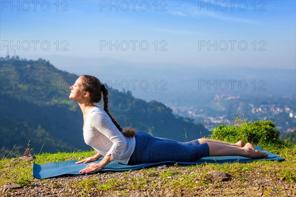 Beautiful sporty fit woman practices yoga asana bhujangasana