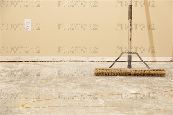 Blank concrete house floor with broom ready for flooring installation