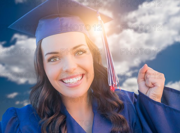 Happy graduating mixed-race woman in cap and gown